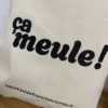 Tote-bag couleur noir, artisanal en coton naturel certifié Oeko-Tex, fabriqué en Franche-Comté avec l'expression "ça meule", sac écologique et original.