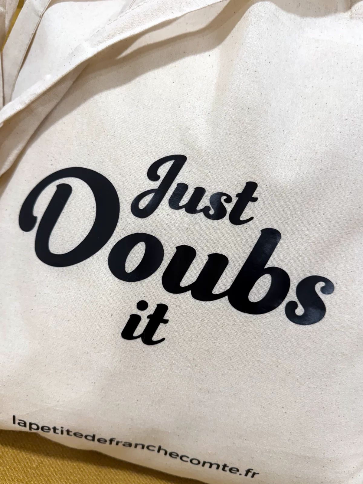 Tote-bag couleur naturel, artisanal en coton naturel certifié Oeko-Tex, fabriqué en Franche-Comté avec expression « Just DOUBS it », sac écologique et original.