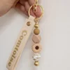 Porte-clés personnalisé artisanal avec perles et breloques. Modèle aléatoire unique, fabriqué avec soin en Franche-Comté.